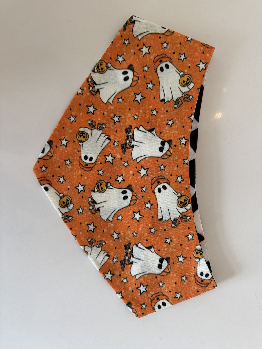Close-up of the orange ghost print on the Groovy Ghosts handmade pet bandana