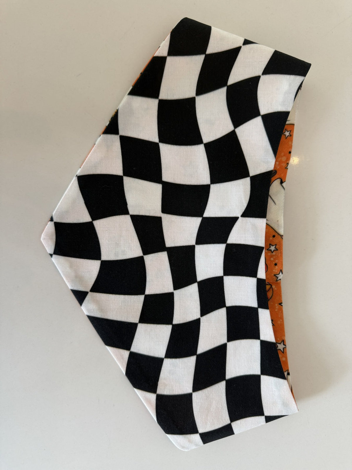 Black-and-white wavy checkerboard reverse side of the Groovy Ghosts pet bandana