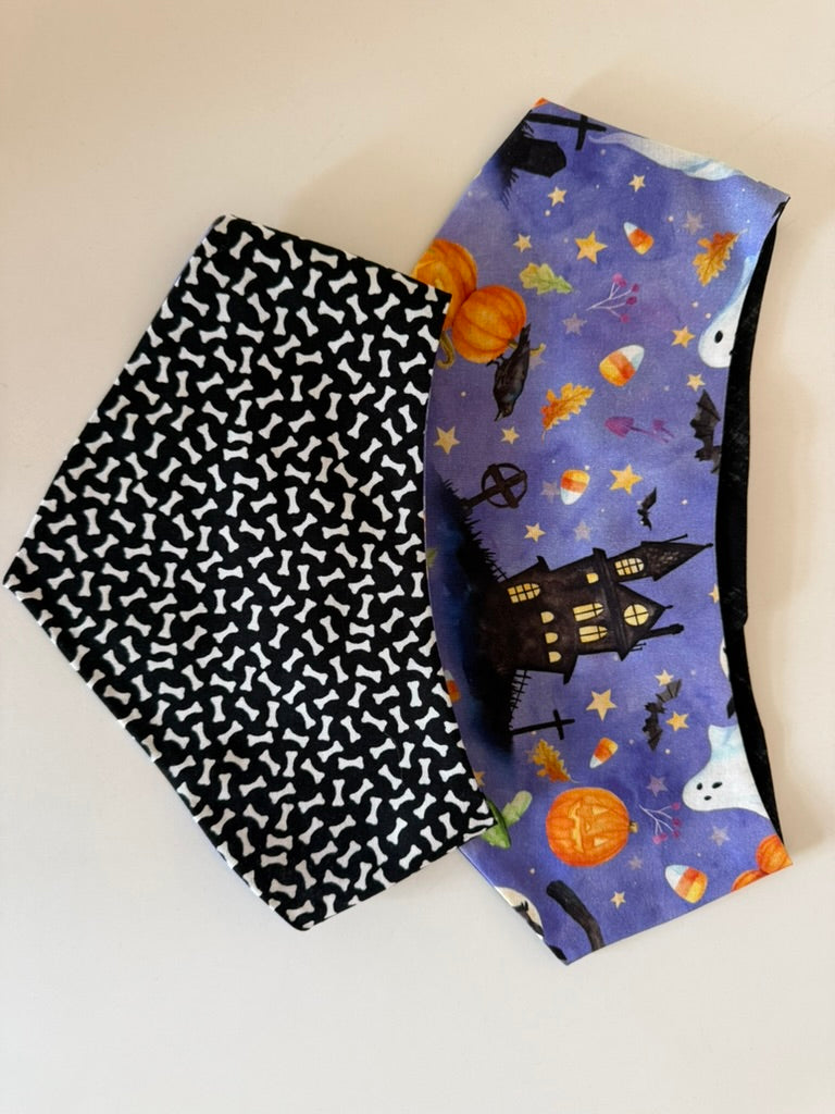 Haunted Howl reversible Halloween pet bandana showing haunted house and bone print sides