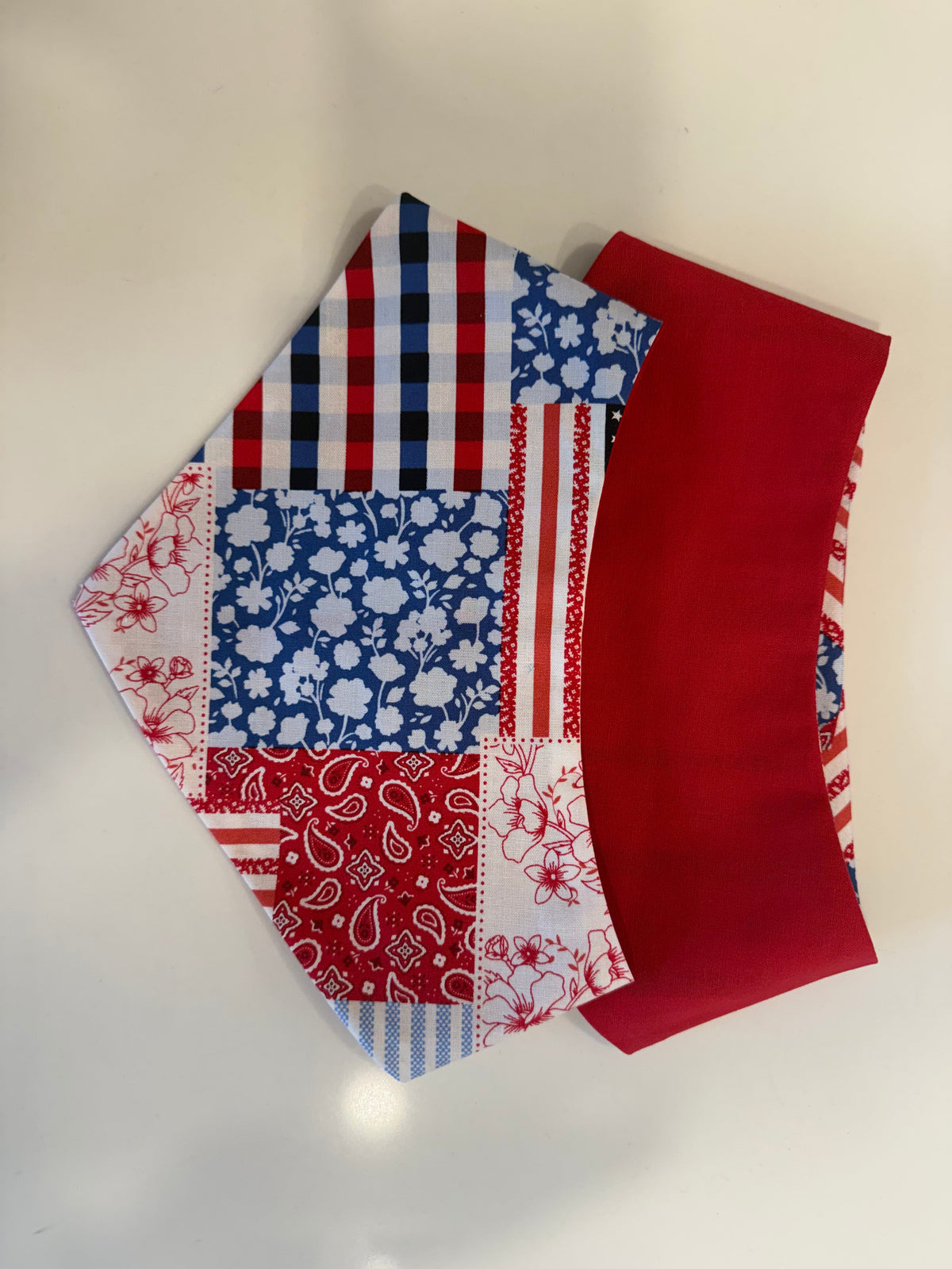 Patchwork Paws reversible pet bandana showing patriotic patchwork and solid red sides