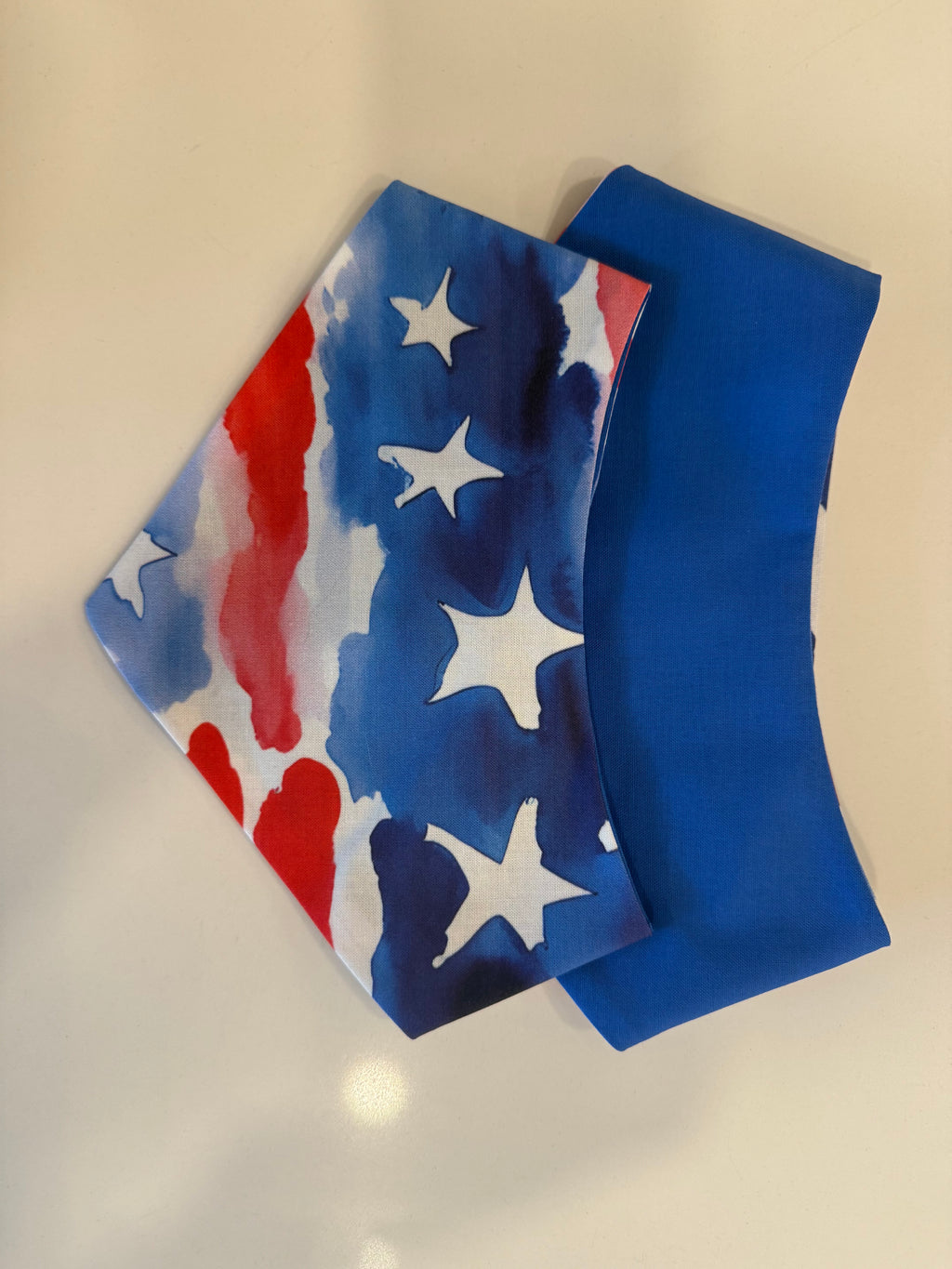 Red White and Woof reversible pet bandana showing watercolor stars and stripes with blue reverse
